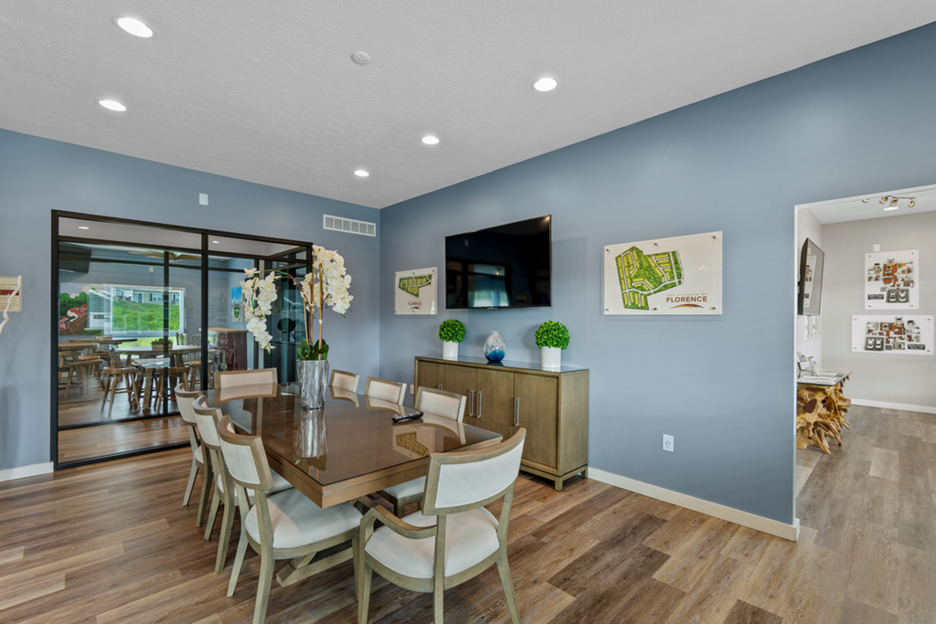 a dining room with a table and chairs and a tv