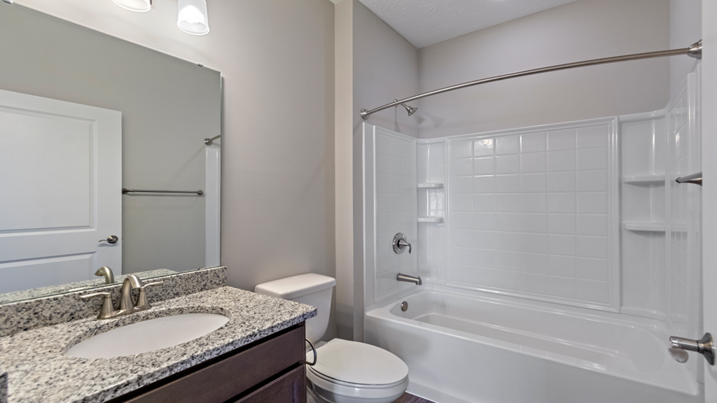 a bathroom with a shower sink and toilet and a mirror