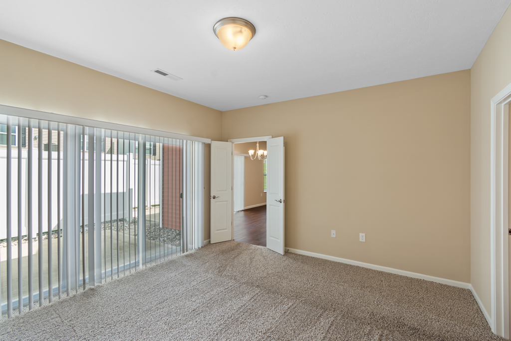 a living room with a sliding glass door and a carpeted floor