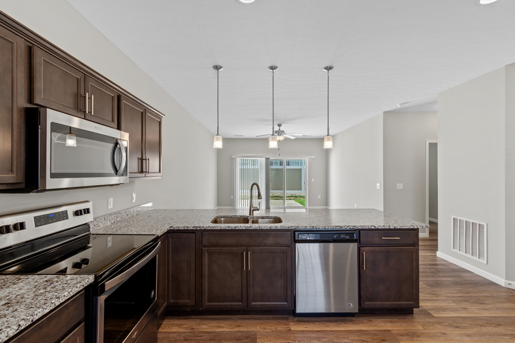 a kitchen with granite counter tops and wooden cabinets