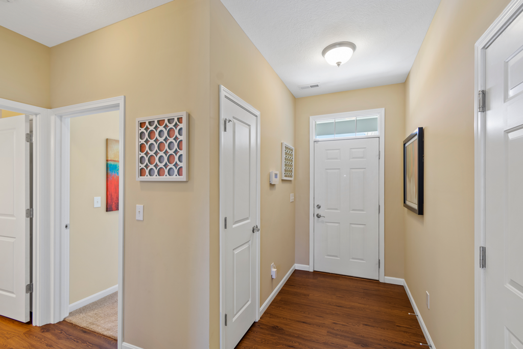 a hallway with two doors and a door to a closet
