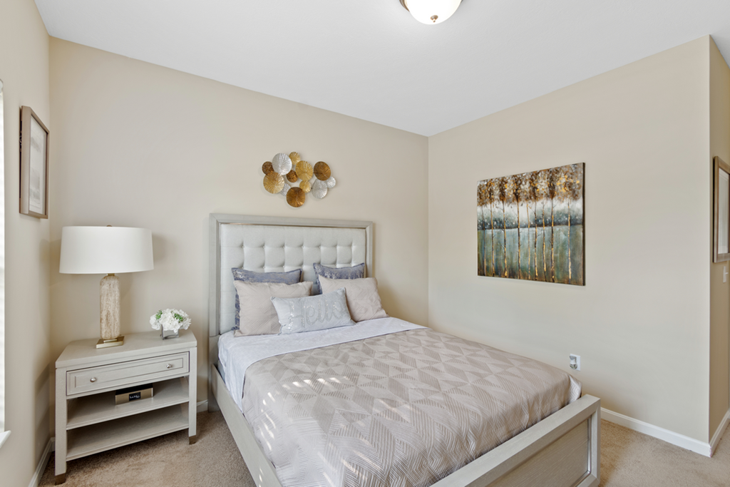 a bedroom with a bed and a night stand with a lamp