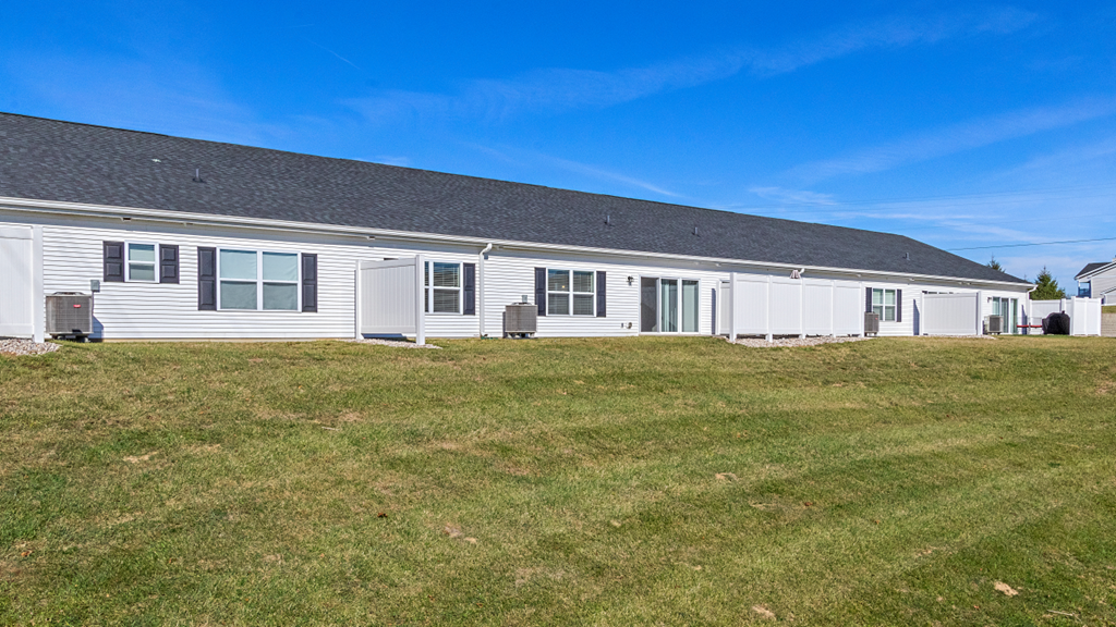 a white house on a hill with a blue sky