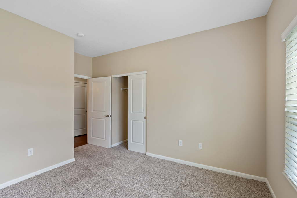 an empty room with two doors and a window