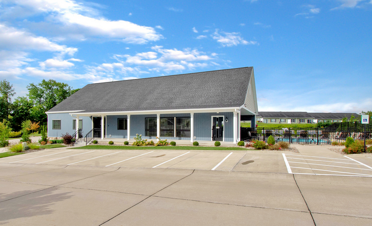 a parking lot in front of a building with a swimming pool