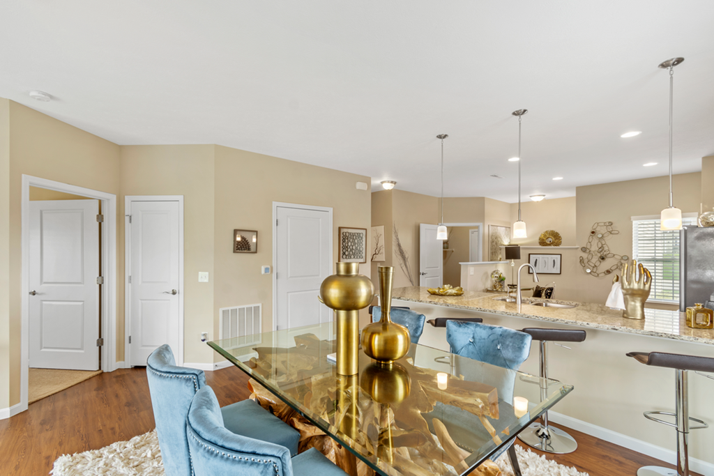 a dining room with a glass table and chairs and a kitchen