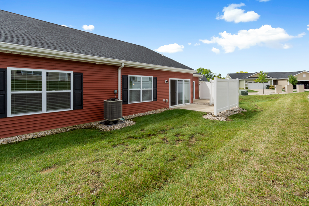a red house with a yard and a white fence