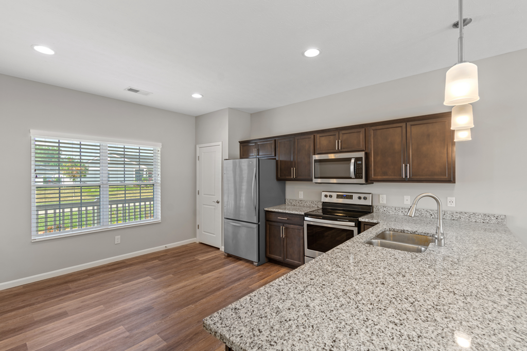 a kitchen with a granite counter top and a stainless steel refrigerator