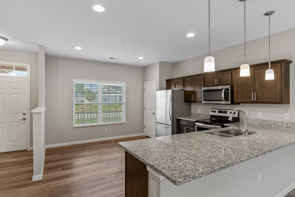 an empty kitchen with a granite counter top and