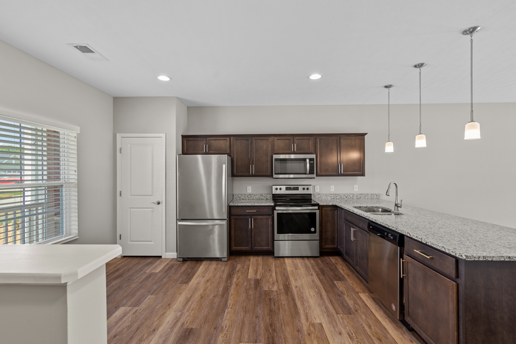 an empty kitchen with wooden cabinets and stainless steel appliances
