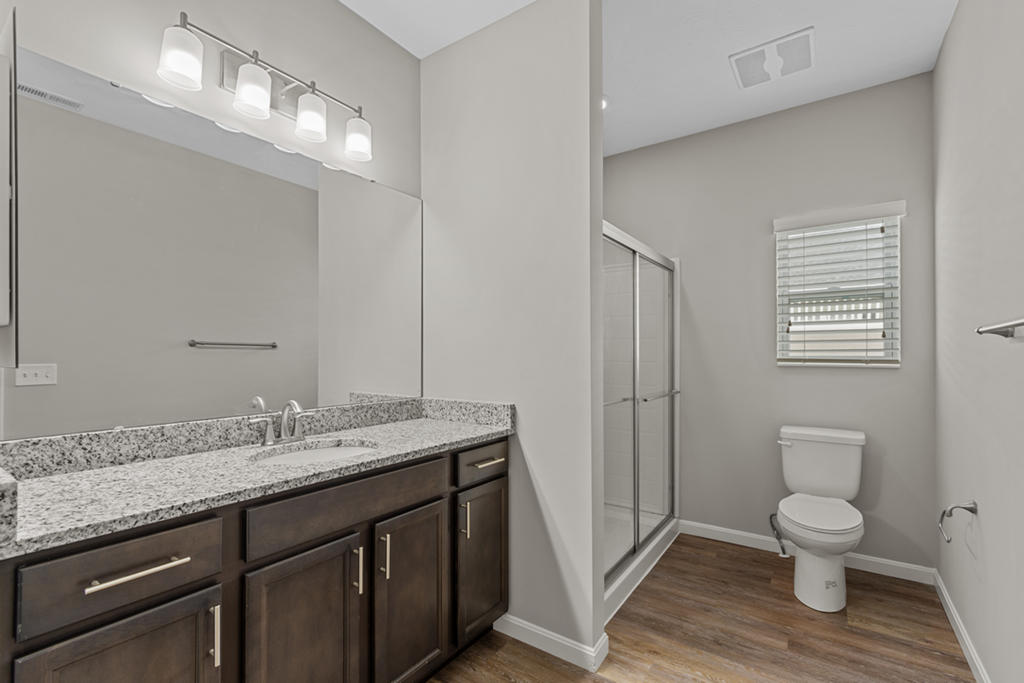 a bathroom with a large mirror and a toilet and a shower