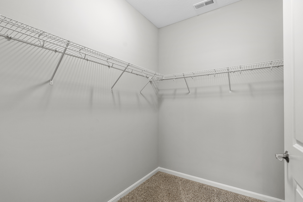 an empty closet with shelves in a white room
