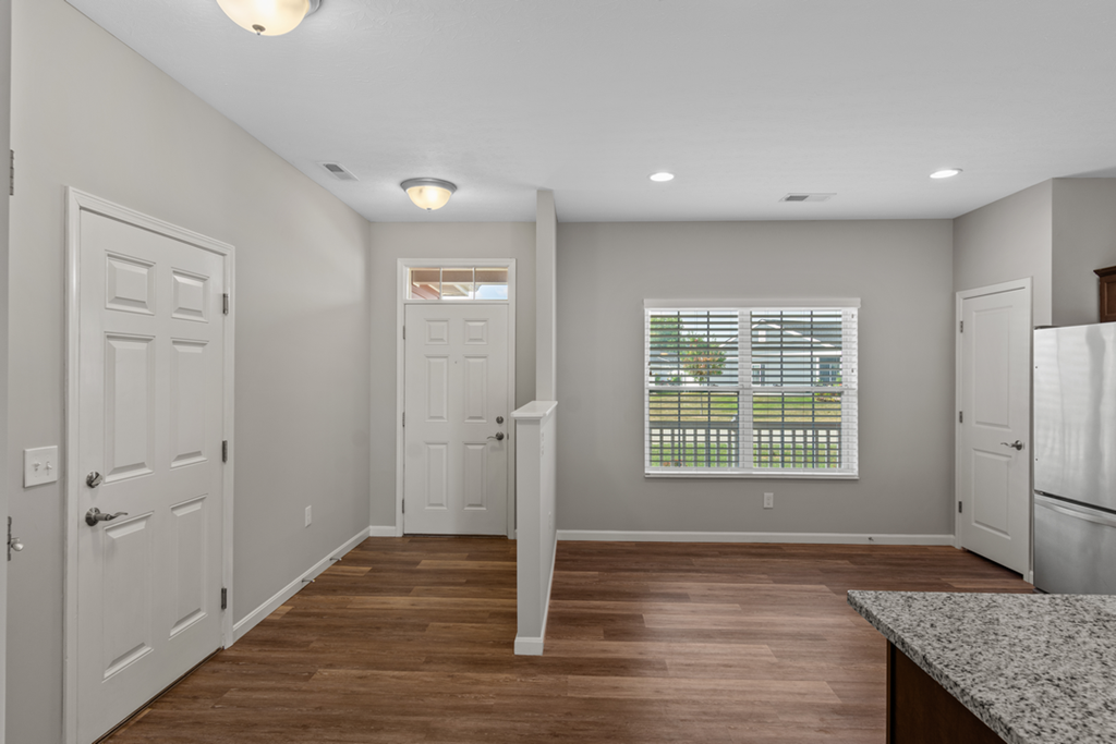 an empty kitchen with white doors and a window