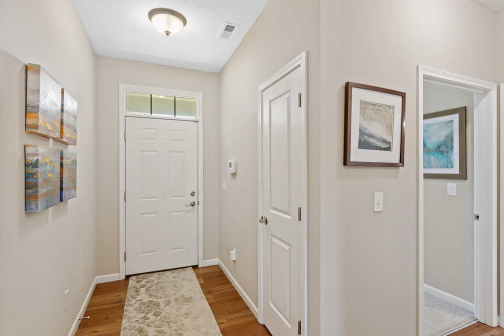 a hallway with two white doors and paintings on the wall