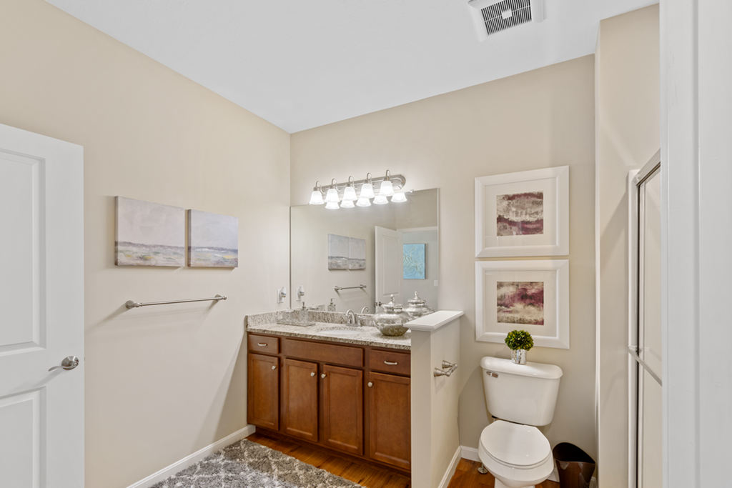 a bathroom with a toilet sink and mirror and a shower