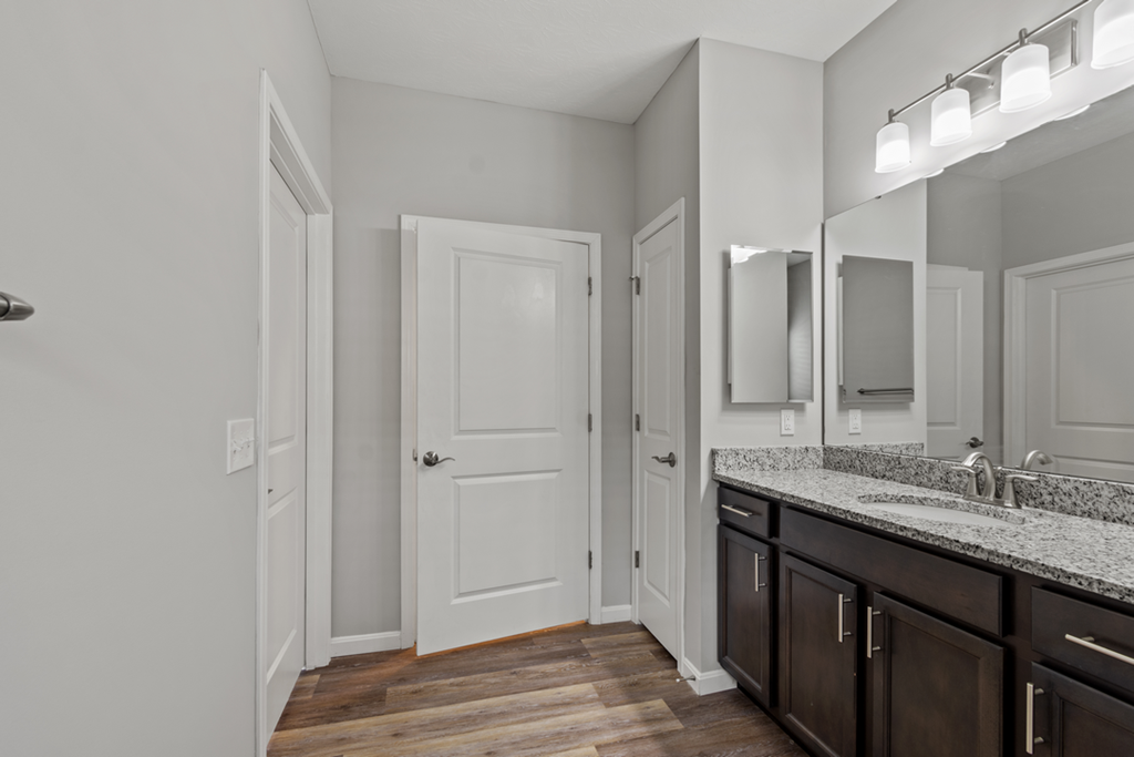 a bathroom with a sink and a mirror and a door