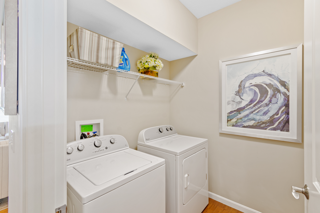 a washer and dryer in a laundry room with a painting on the wall