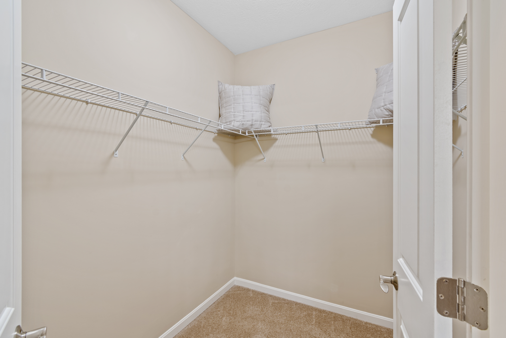 an empty closet with shelves and a chair in the closet