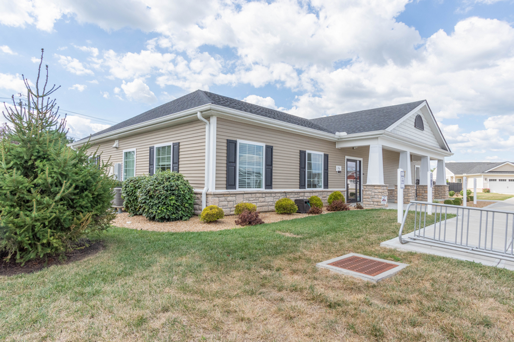 A house with a grey roof and a white fence.