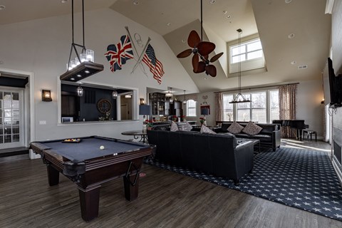 Elegant clubhouse at Queens Gate Apartments featuring a pool table, cozy lounge area, and stylish decor.
