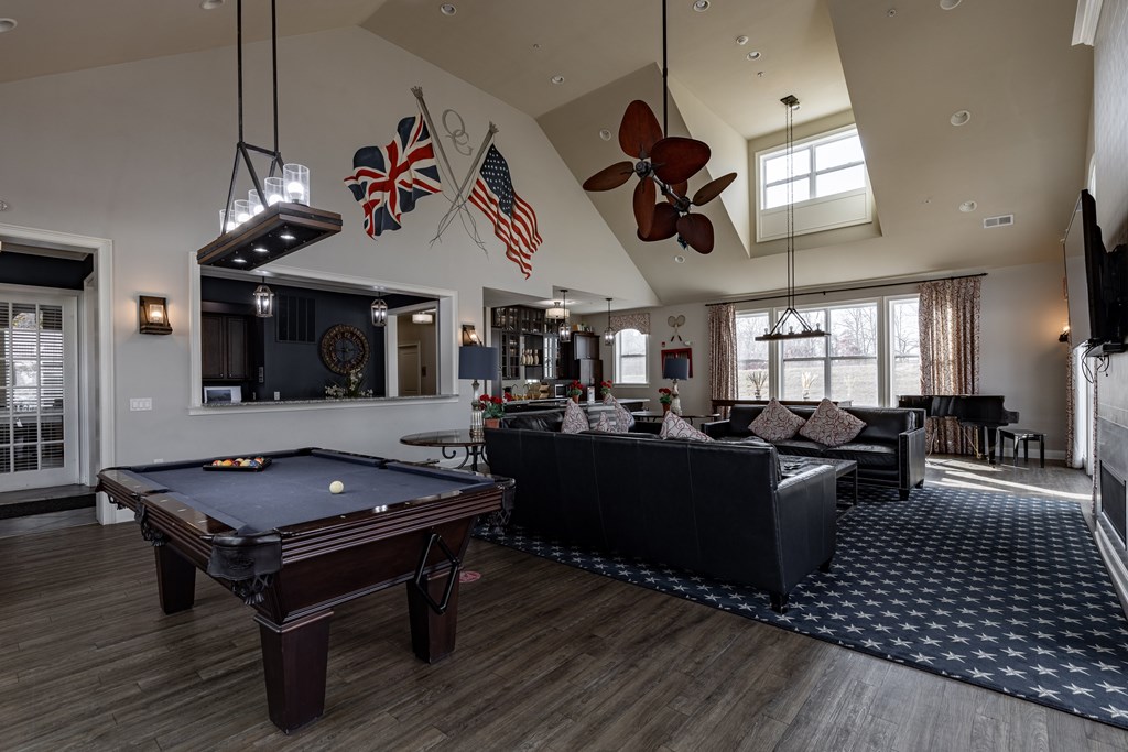 Elegant clubhouse at Queens Gate Apartments featuring a pool table, cozy lounge area, and stylish decor.