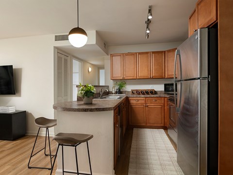A kitchen with wooden cabinets and a refrigerator.