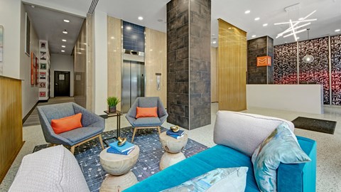 A living room with a grey sofa, two chairs and a table.