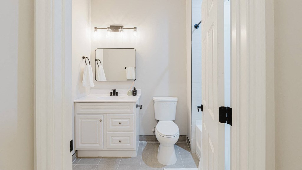 a white bathroom with a toilet and a sink