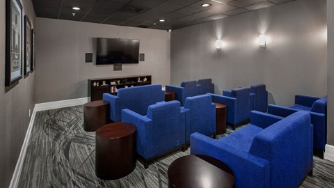 a living room with blue chairs and a television