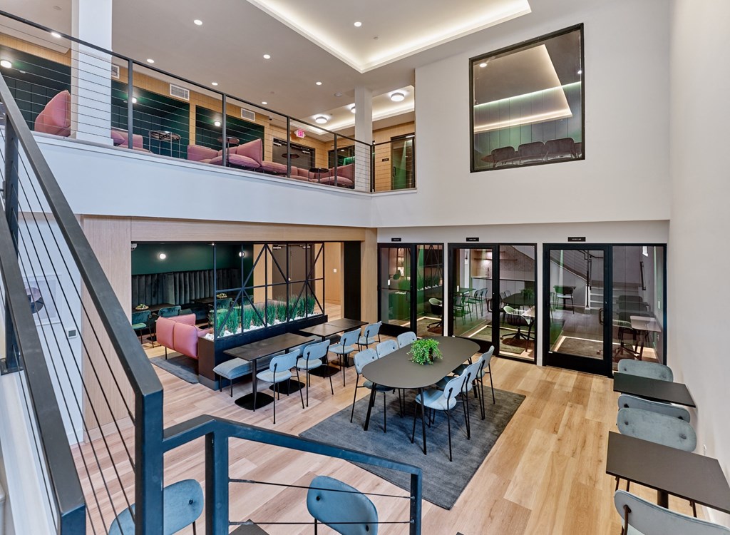 a large lobby with tables and chairs and glass doors