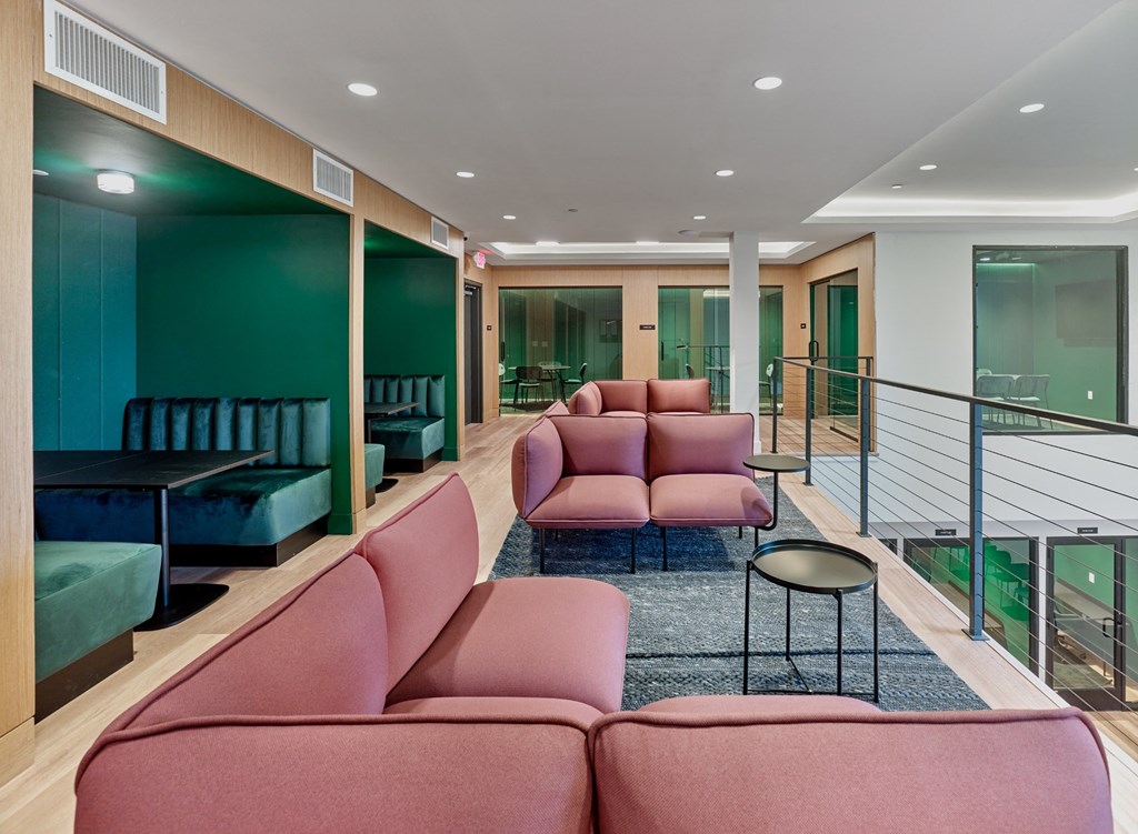 a living room with pink couches and a blue rug
