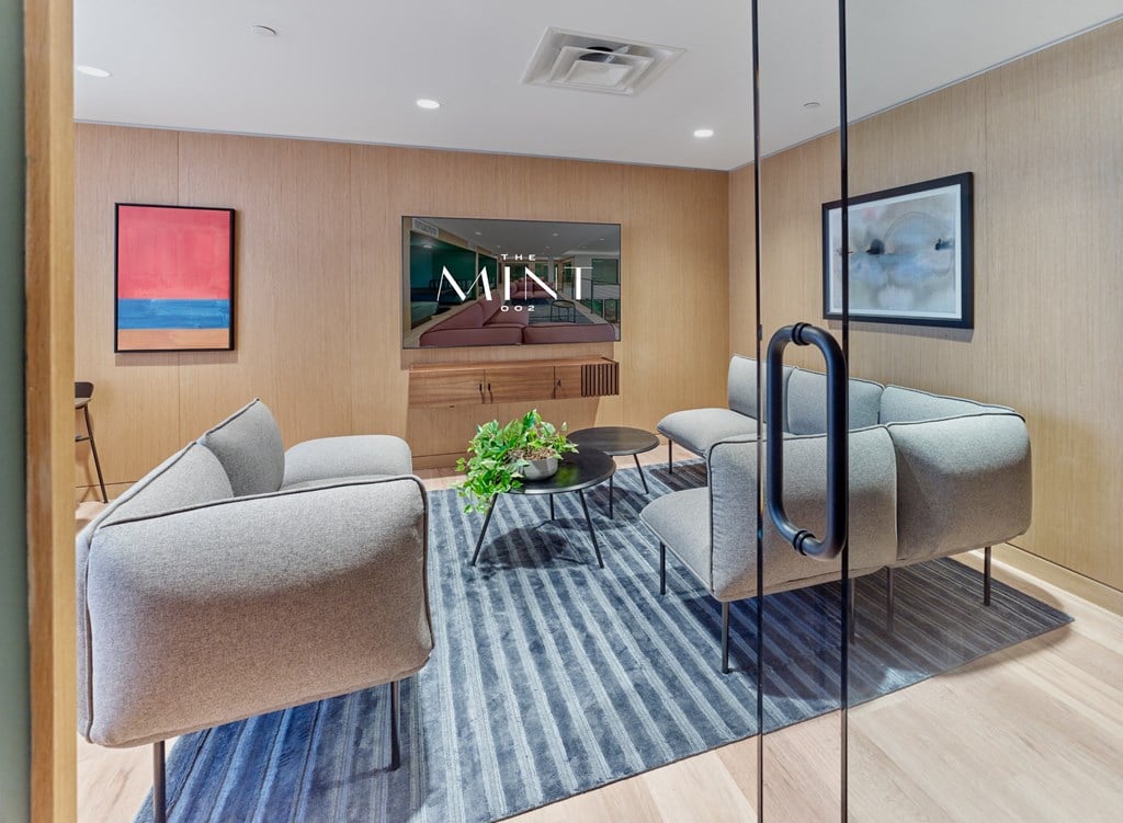 a living room with couches and chairs and a television