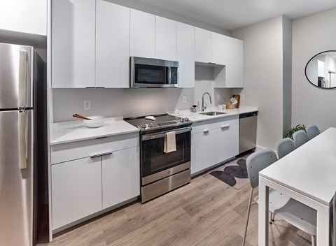a kitchen with white cabinets and stainless steel appliances