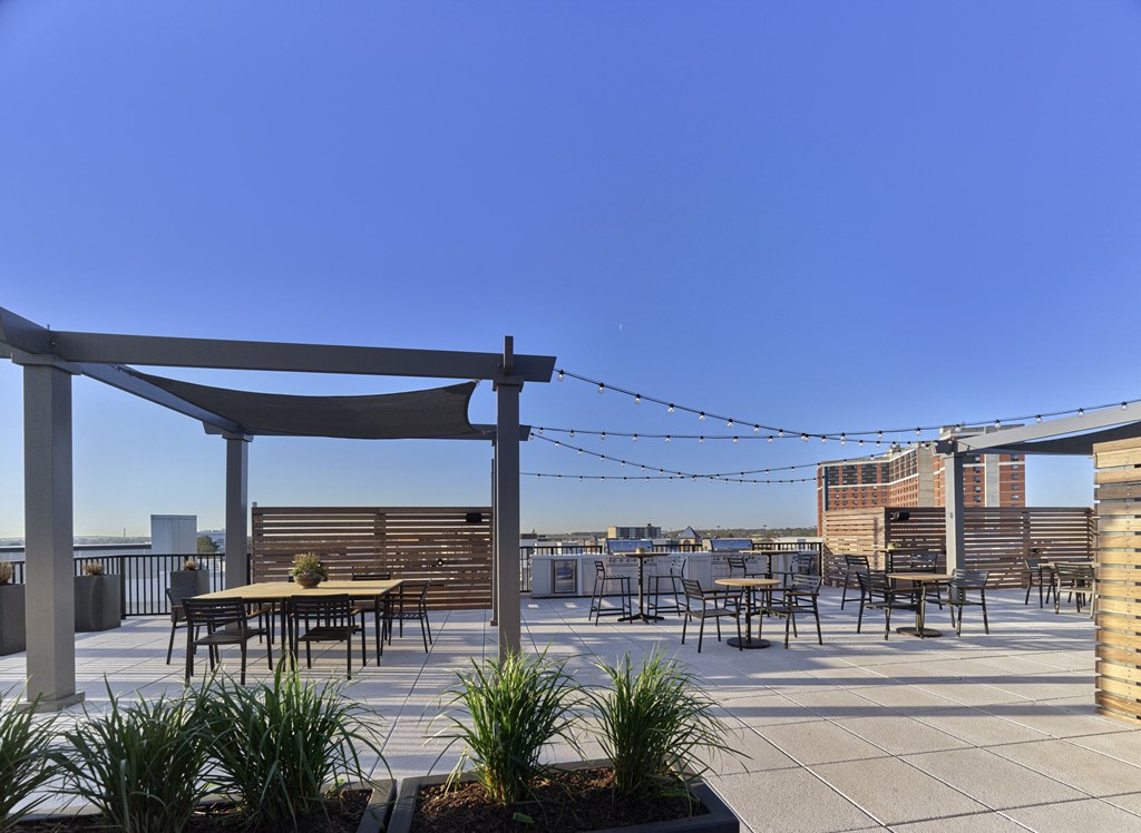 a roof top patio with tables and chairs and a canopy