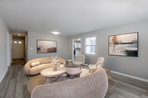 A living room with a large couch and two chairs.