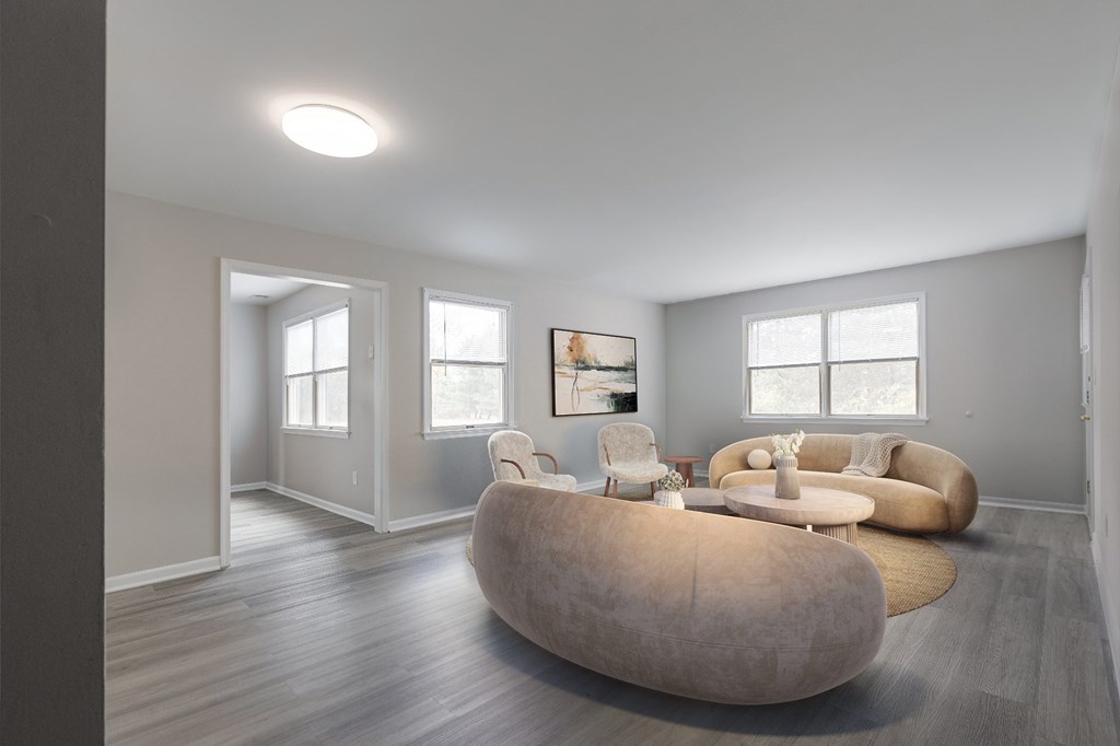 A bright and airy living space at The Village at Bridgewater in Bridgewater, NJ. Features multiple windows, neutral walls, and a seamless connection to adjacent rooms for an open feel.