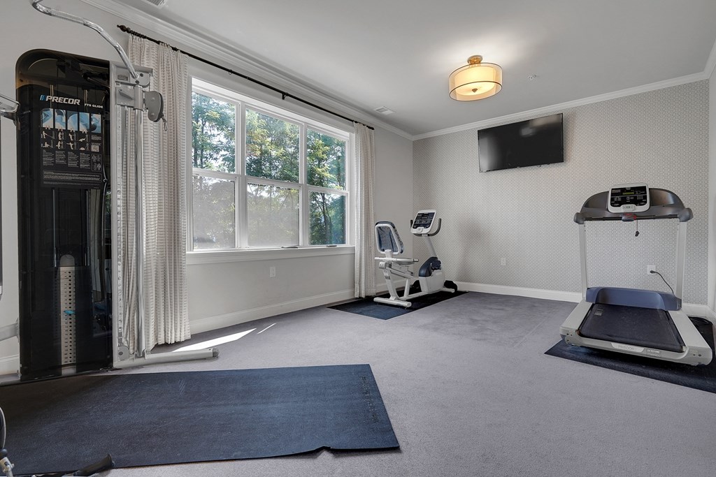 a home gym with exercise equipment and a window