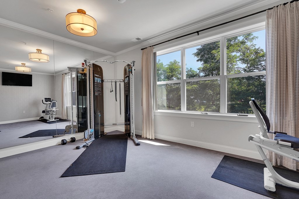 a home gym with a large window and exercise equipment