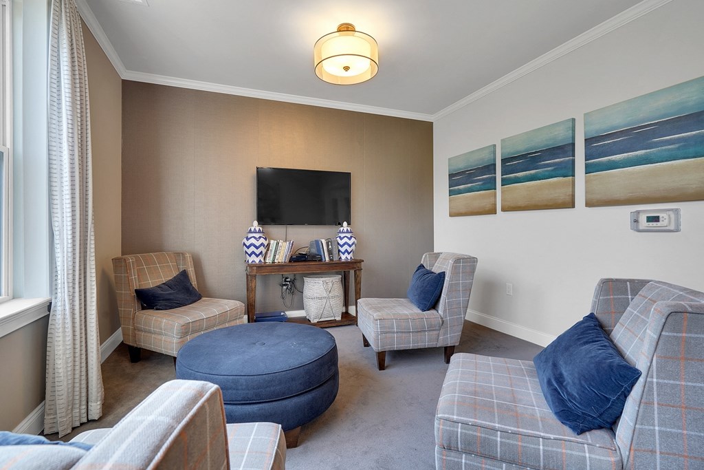 a living room with couches and chairs and a television