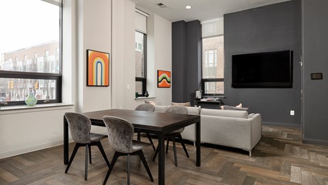 Spacious resident lounge with a large-screen TV and herringbone flooring, typical of upscale Rittenhouse Square apartments Philadelphia PA.