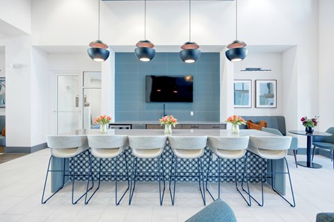 A modern dining room with a long table and chairs.