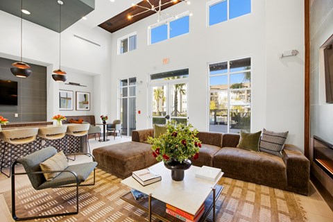 A living room with a brown couch, a coffee table, and a large window.