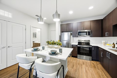 A modern kitchen with a white table and chairs.