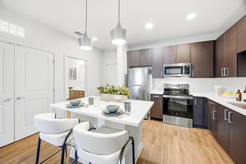 A modern kitchen with a white table and chairs.