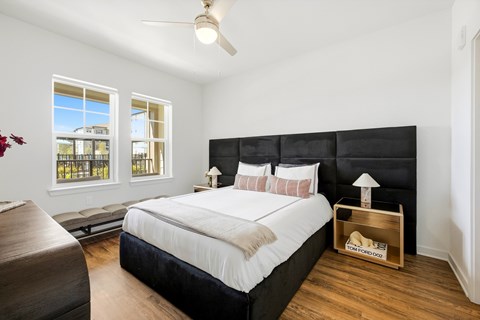 A bedroom with a large bed and a window overlooking a building.