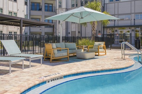 A pool with a blue border and a white umbrella.