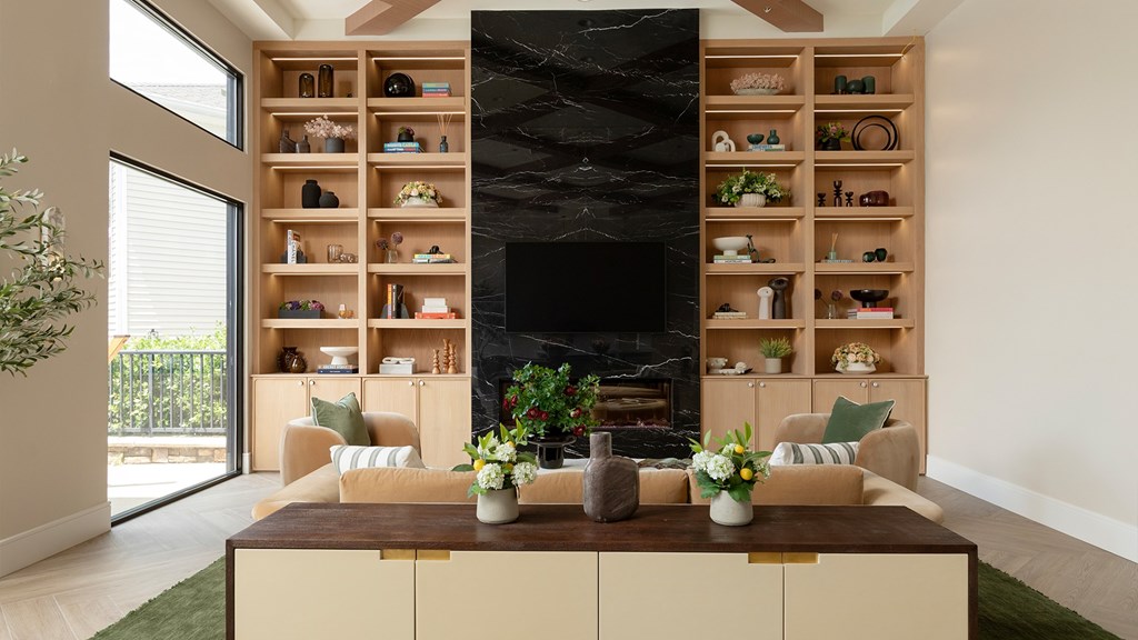 Designer lounge with a black marble fireplace and custom shelving at The Mews at Princeton Junction, offering luxurious condo-style living in Princeton NJ.