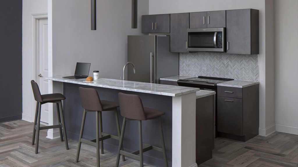 Kitchen with breakfast bar and stainless steel appliances at Philadelphia Apartments