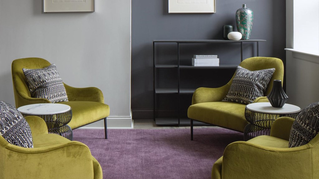 Three yellow chairs with pillows are arranged in a room.