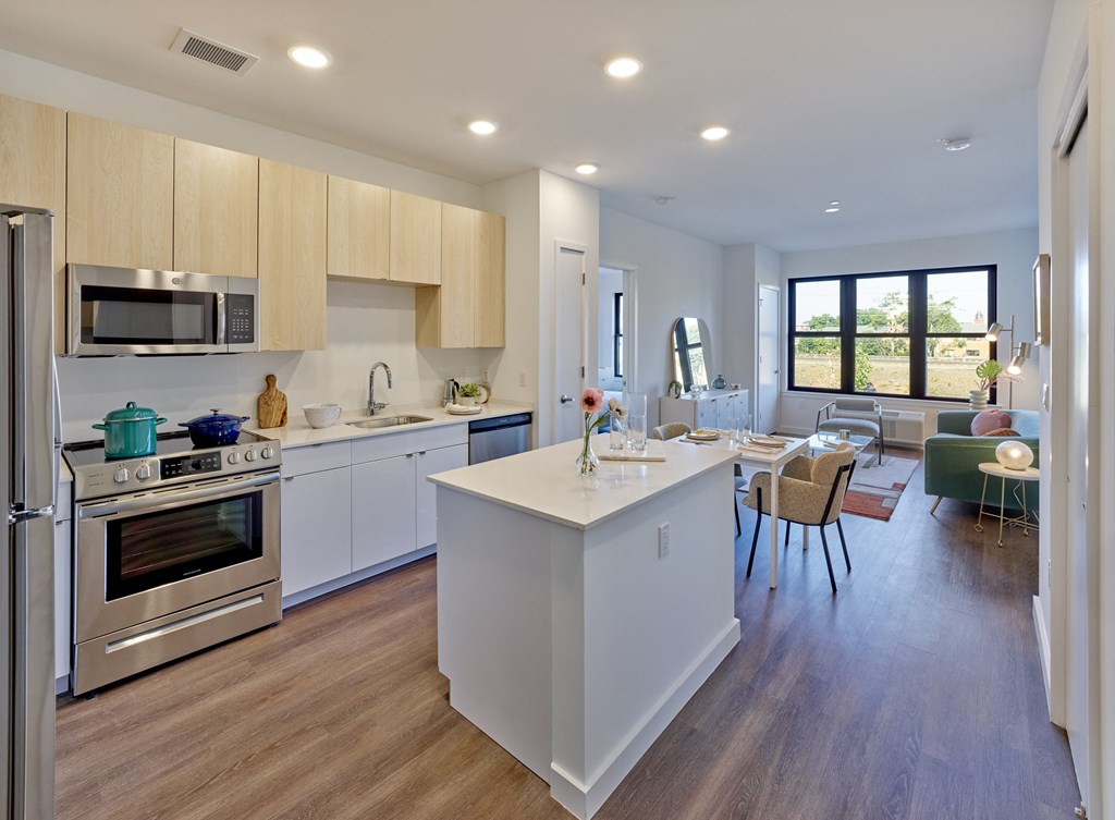 a kitchen with an island and a dining room with a table and chairs